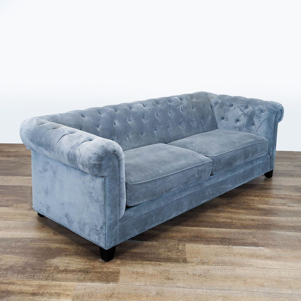 2. Angled view of Macy's 3-seat light blue velvet sofa with classic tufted back and rolled arms.