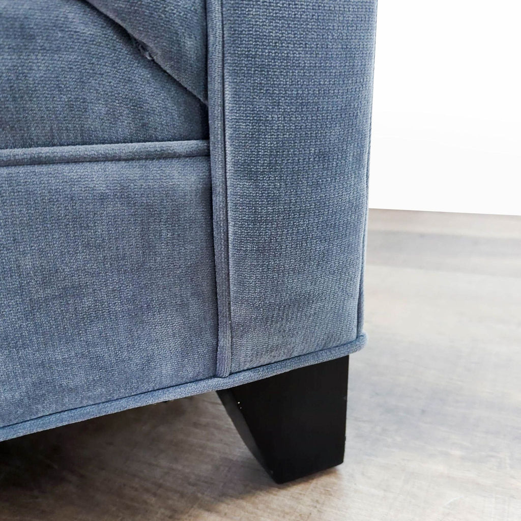 3. Close-up of the light blue velvet fabric and dark wooden leg of the Macy's 3-seat sofa.