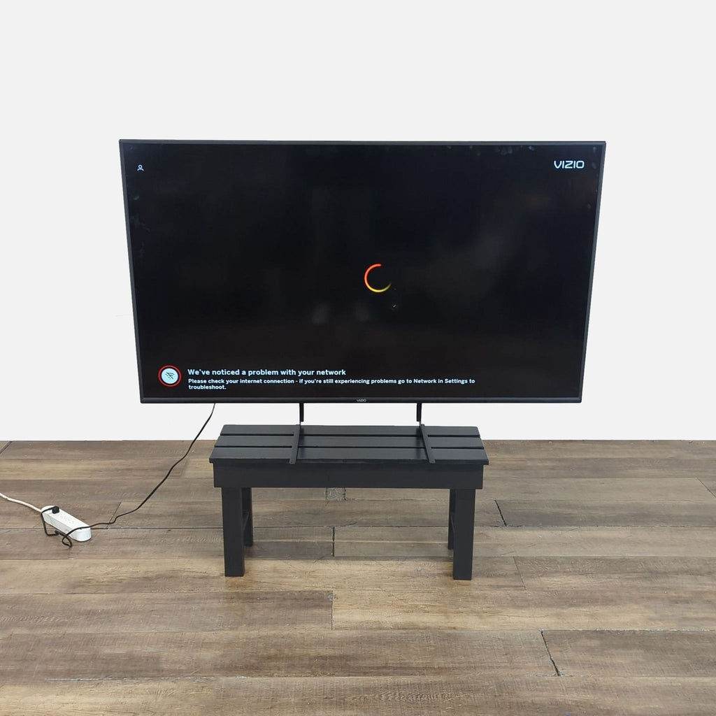 Vizio brand 43-inch television on a stand, powered on with a network issue prompt visible on the screen.