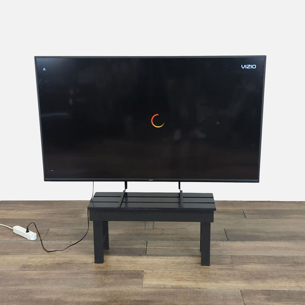 1. Vizio 70-inch flat screen TV with a slim bezel, displayed on a black stand in a modern room.