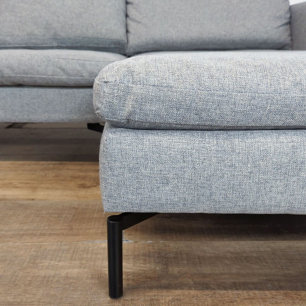 Blu Dot sectional with modern wide arms, plush cushions, and distinctive powder-coated angular legs.