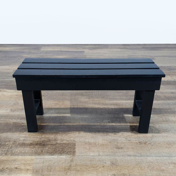 1. Black wooden Reperch bench with slatted top, shown on a wood floor, category Stools, Ottomans & Benches.  
