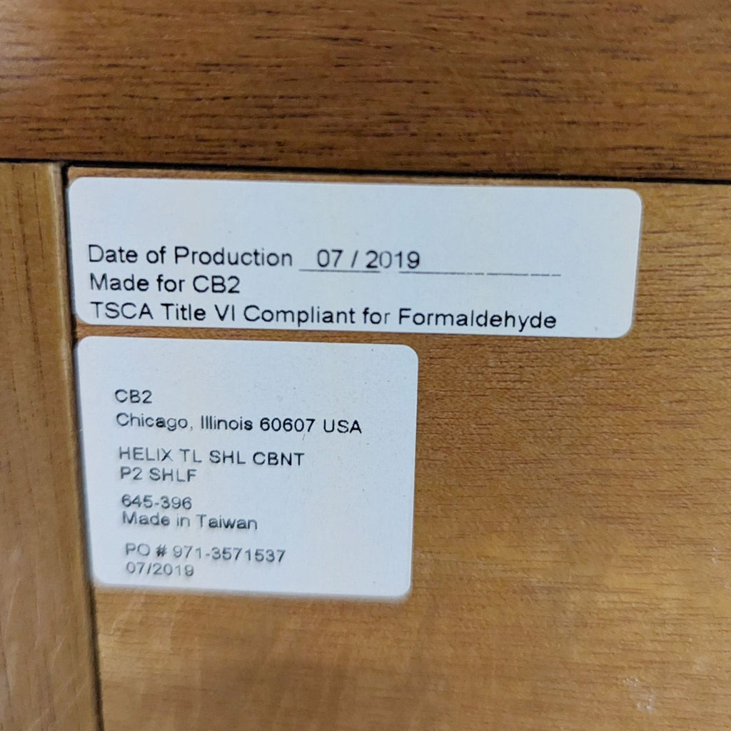 3. Close-up label on CB2 bookshelf with production info, compliance, and manufacturing details.