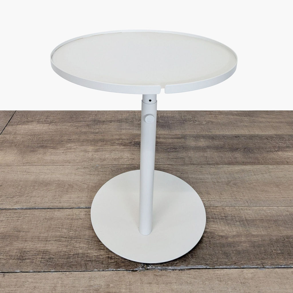 1. Modern round white Reperch side table with a central pedestal base, standing on a wooden floor.  