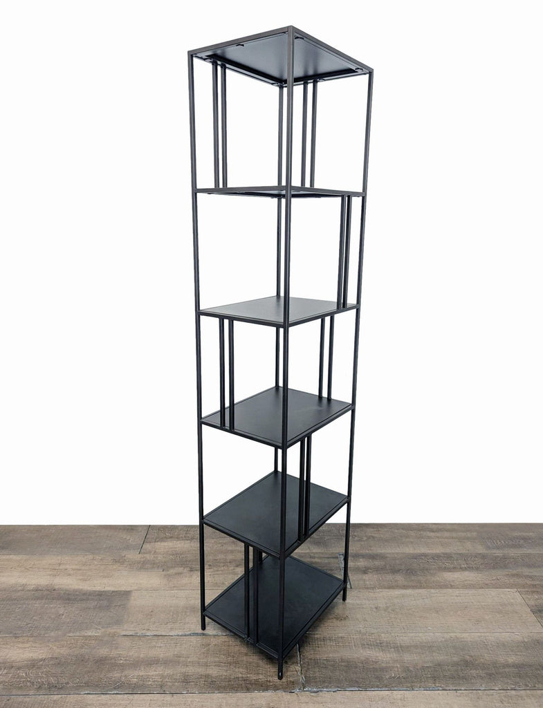 2. Angled view of industrial-inspired West Elm bookshelf, featuring staggered shelving and a slender metal frame.