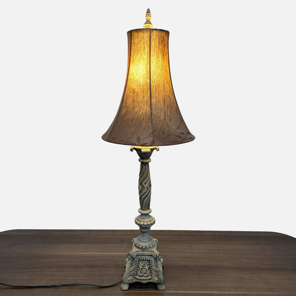 Ornate vintage-style Reperch table lamp with a fabric shade, displayed on a wooden surface.  