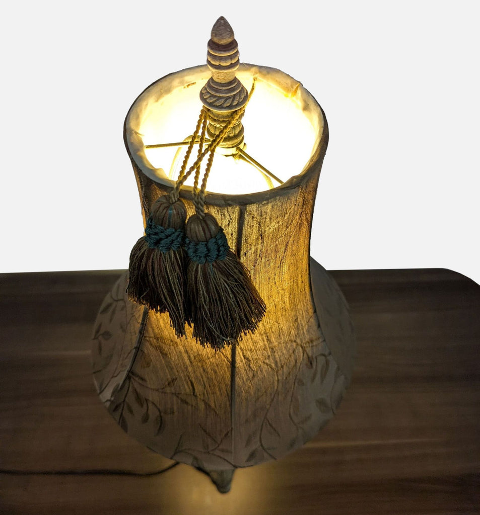 Top-down view of a Reperch lamp showing a glowing fabric shade and decorative tassels, vintage design.  