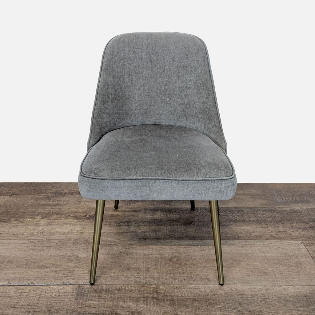 1. Front view of West Elm dining chair in performance grey velvet with slim brass legs on wood floor.  