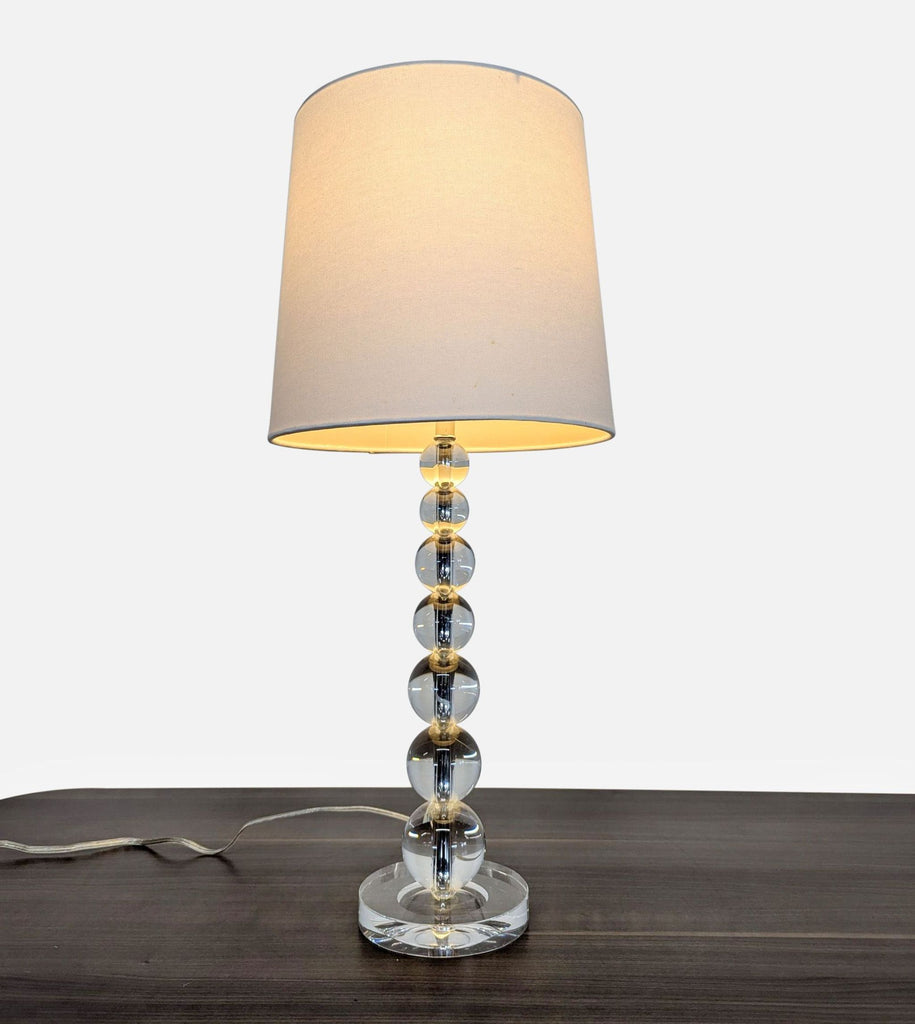 1. Pottery Barn lamp with a base of stacked crystal orbs and a linen lampshade for ambient lighting.
