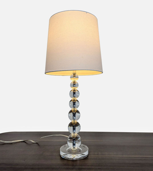 1. Pottery Barn lamp with a base of stacked crystal orbs and a linen lampshade for ambient lighting.