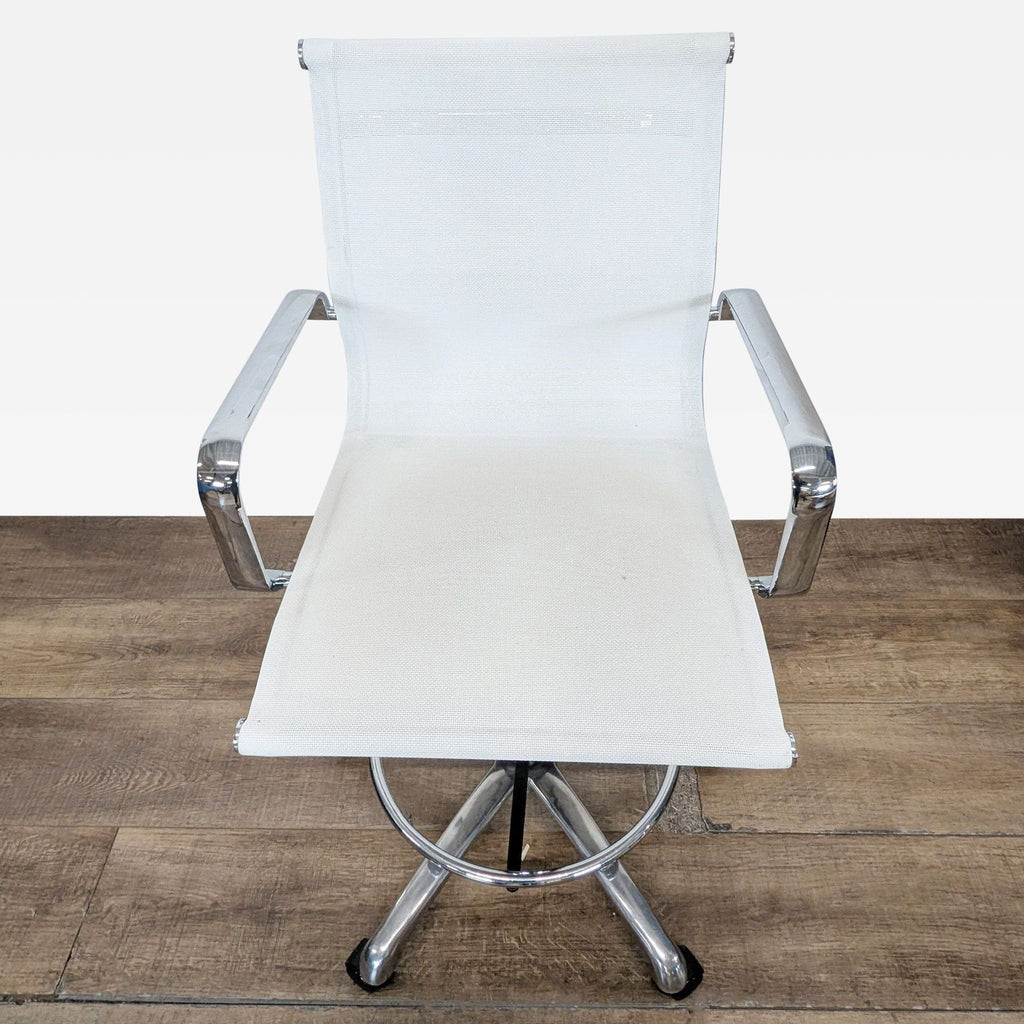 3. Side view of a white adjustable office stool with chrome accents, foot ring, and rolling base.