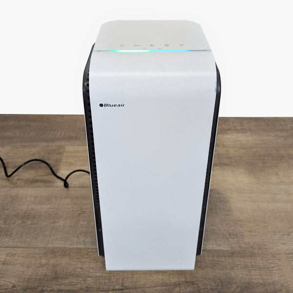 1. Blueair air purifier with a compact, modern design and touch controls, placed on a wooden surface.