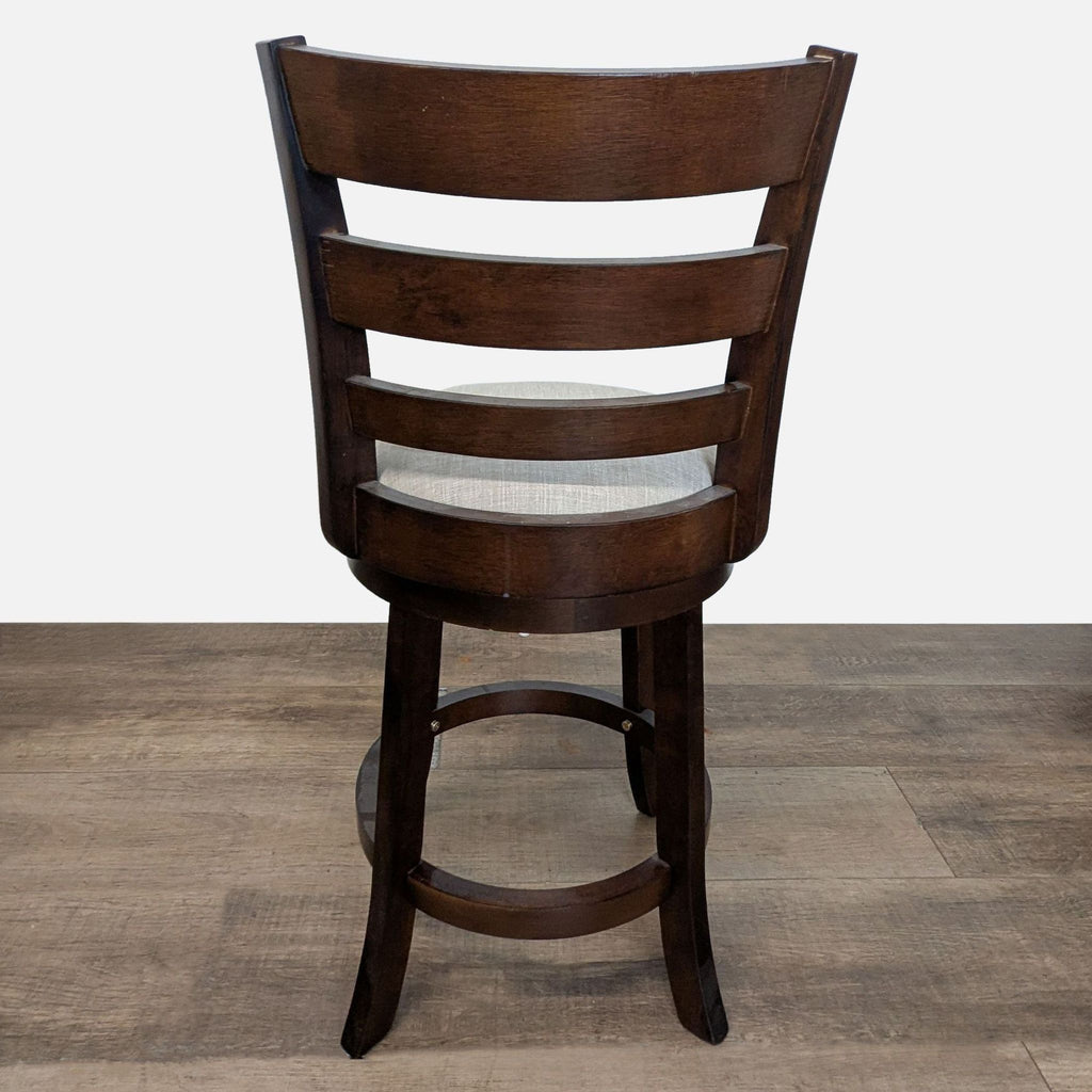 2. Rear view of a Reperch stool showing a slatted wooden backrest and circular footrest design.
