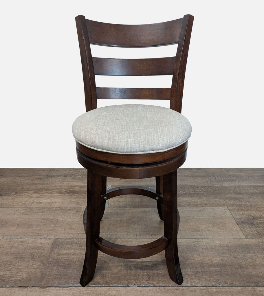 1. Front view of a Reperch stool with a dark wood frame and a light upholstered round cushion seat.