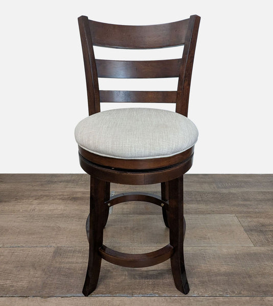 1. Front view of a Reperch stool with a dark wood frame and a light upholstered round cushion seat.
