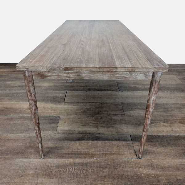 1. Rectangular West Elm dining table with slim wooden legs and a natural wood grain finish on brown flooring.