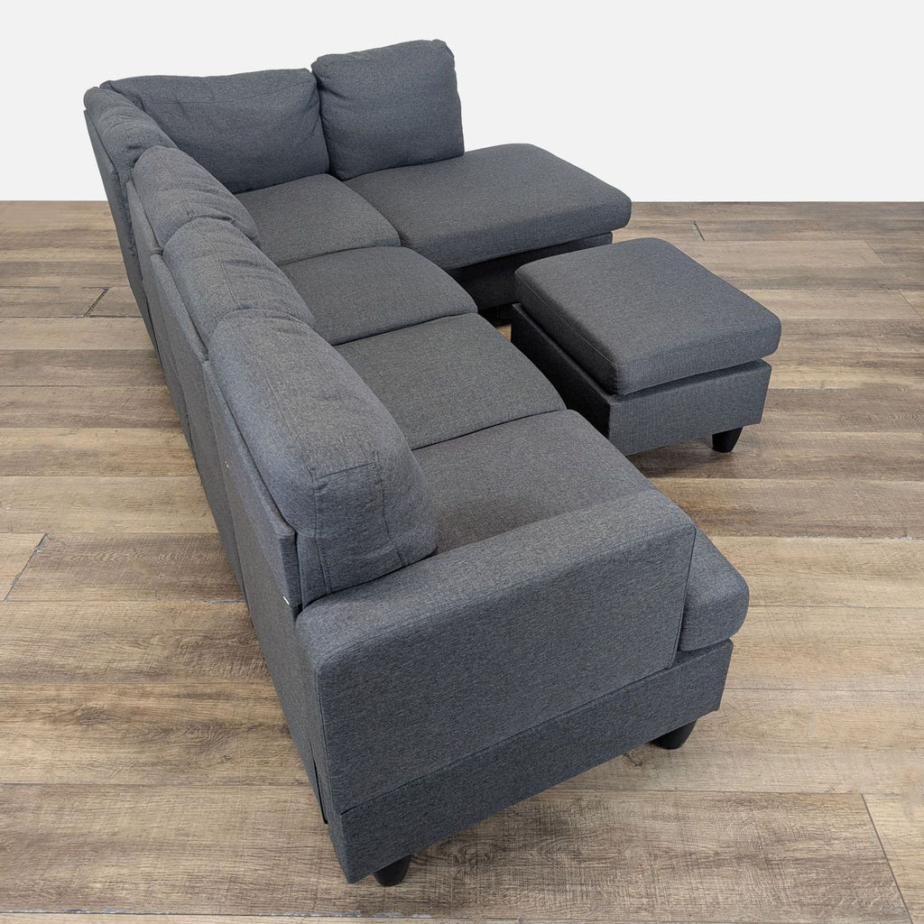 2. Side view of a spacious dark gray Reperch sectional and ottoman, showing ample seating and soft cushions.