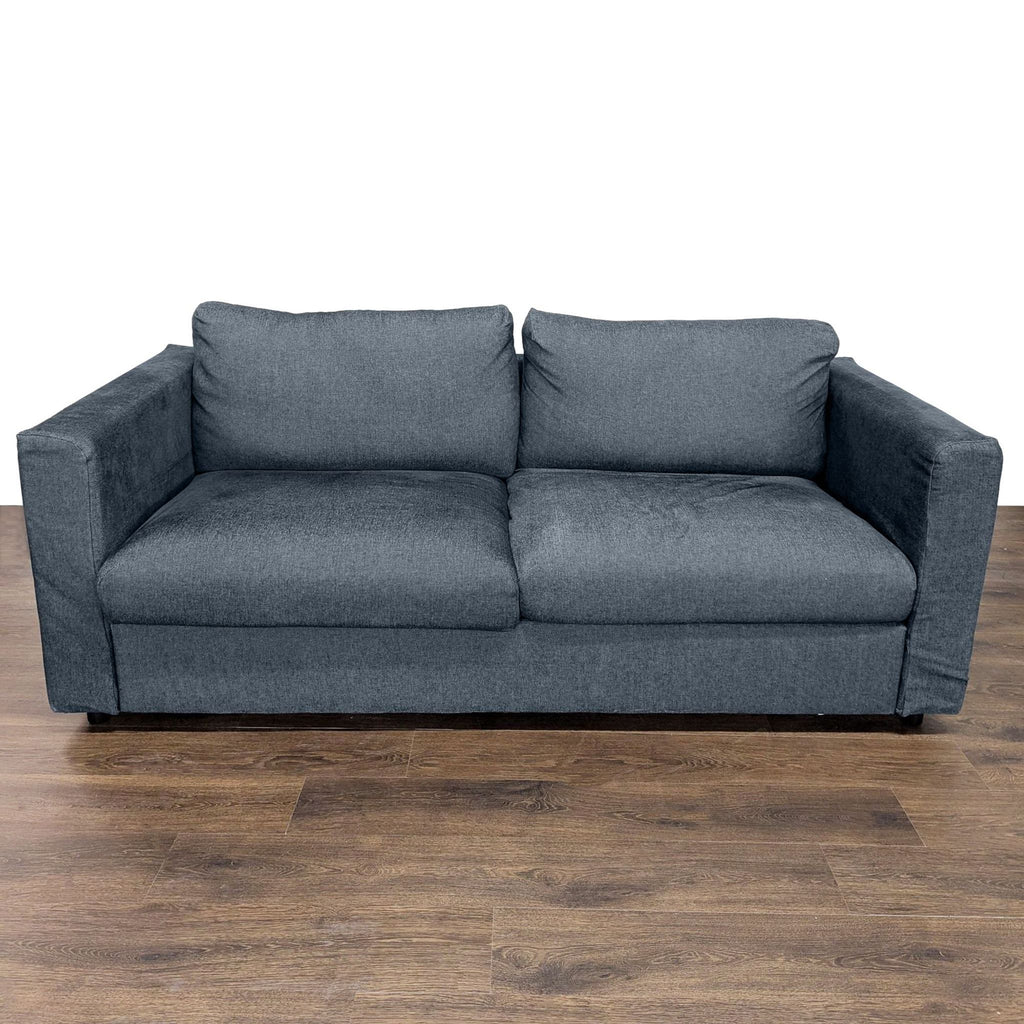 1. Front view of a dark gray Ikea sleeper sofa with plush cushions on a wooden floor.
