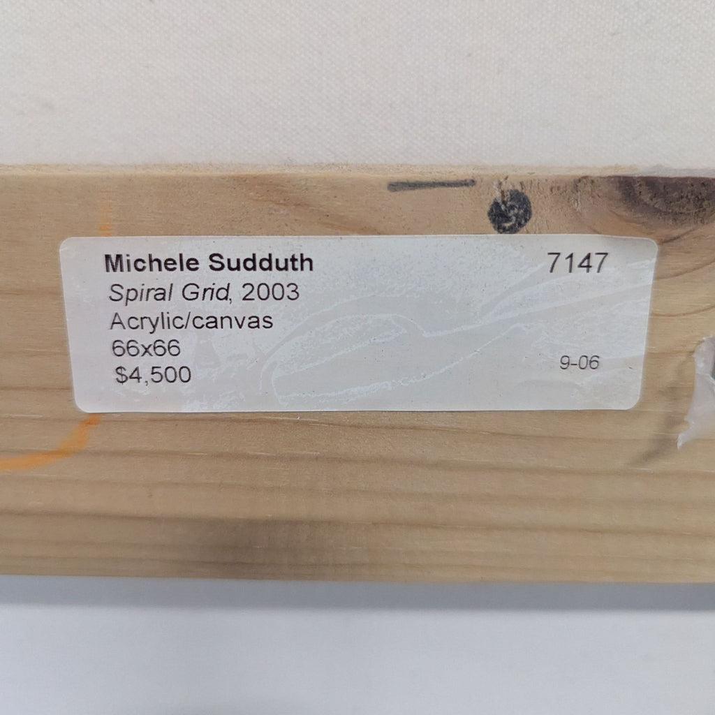 1. Close-up of a wooden stretcher bar with a label for "Spiral Grid" by Michele Sudduth, acrylic on canvas, 66x66, $4,500.  