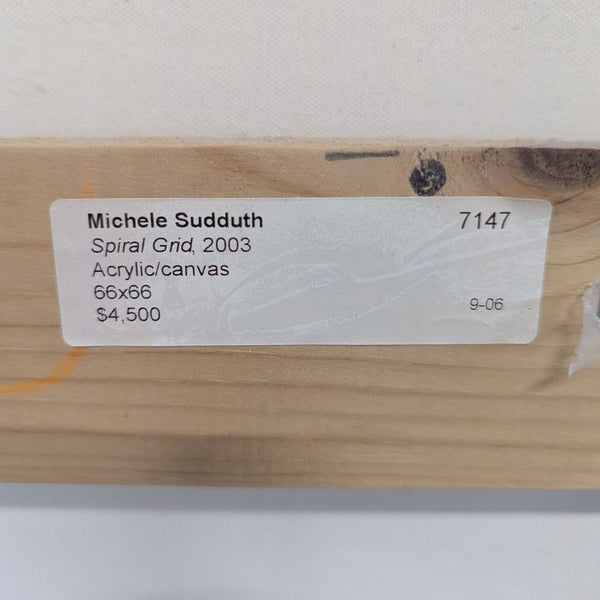 1. Close-up of a wooden stretcher bar with a label for "Spiral Grid" by Michele Sudduth, acrylic on canvas, 66x66, $4,500.  