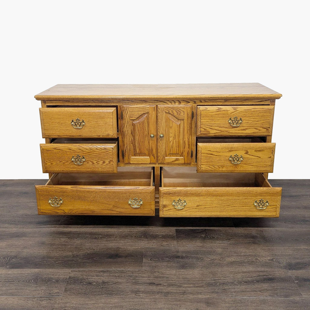 3. Oak dresser by Reperch with eight drawers, some drawers open to display storage capacity, on wood floor.