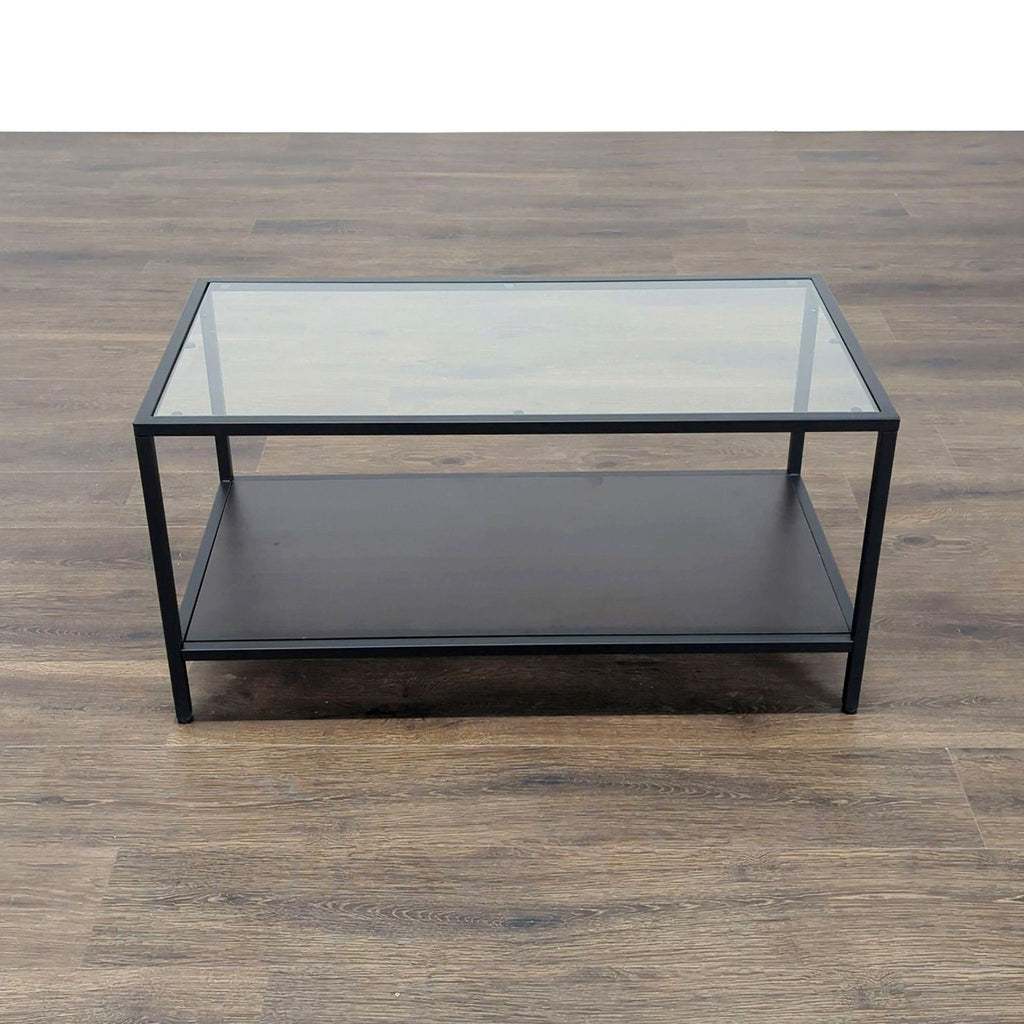 Rectangular Reperch coffee table with a glass top, black frame, and lower shelf on a wood floor.  