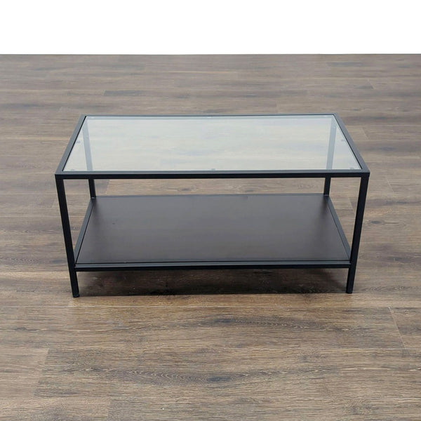Rectangular Reperch coffee table with a glass top, black frame, and lower shelf on a wood floor.  