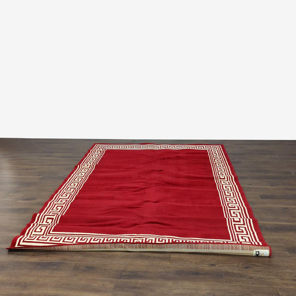 1. Red Taj Mahal rug with cream Greek key border, made from 100% polypropylene, displayed on wooden floor.