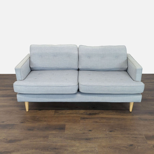Light gray Reperch loveseat with button-tufted loose cushions, slim arms, and wooden feet on a wood floor.