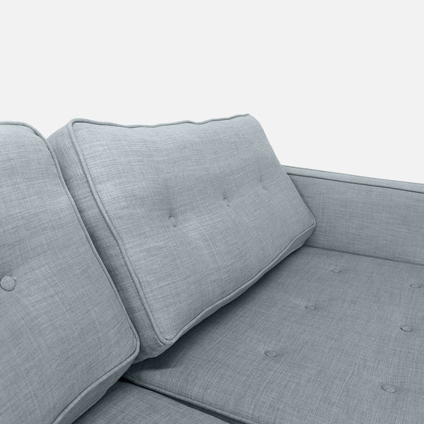 1. Close-up of a Reperch Loveseat’s light gray button-tufted backrest and seat cushions.