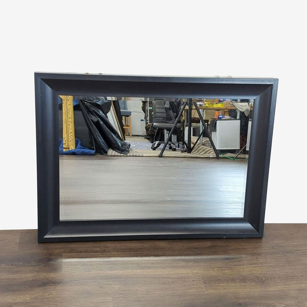 Rectangular Target Home wall mirror with a wide black frame, reflecting a room with office furniture.  