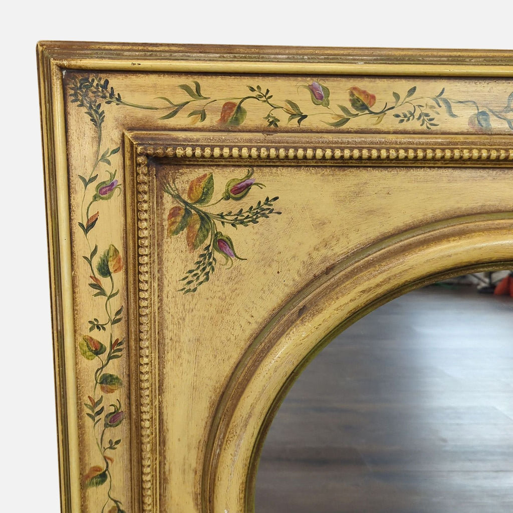 3. Close-up of hand painted floral designs on the golden antiqued wood frame of a Roma Moulding mirror.