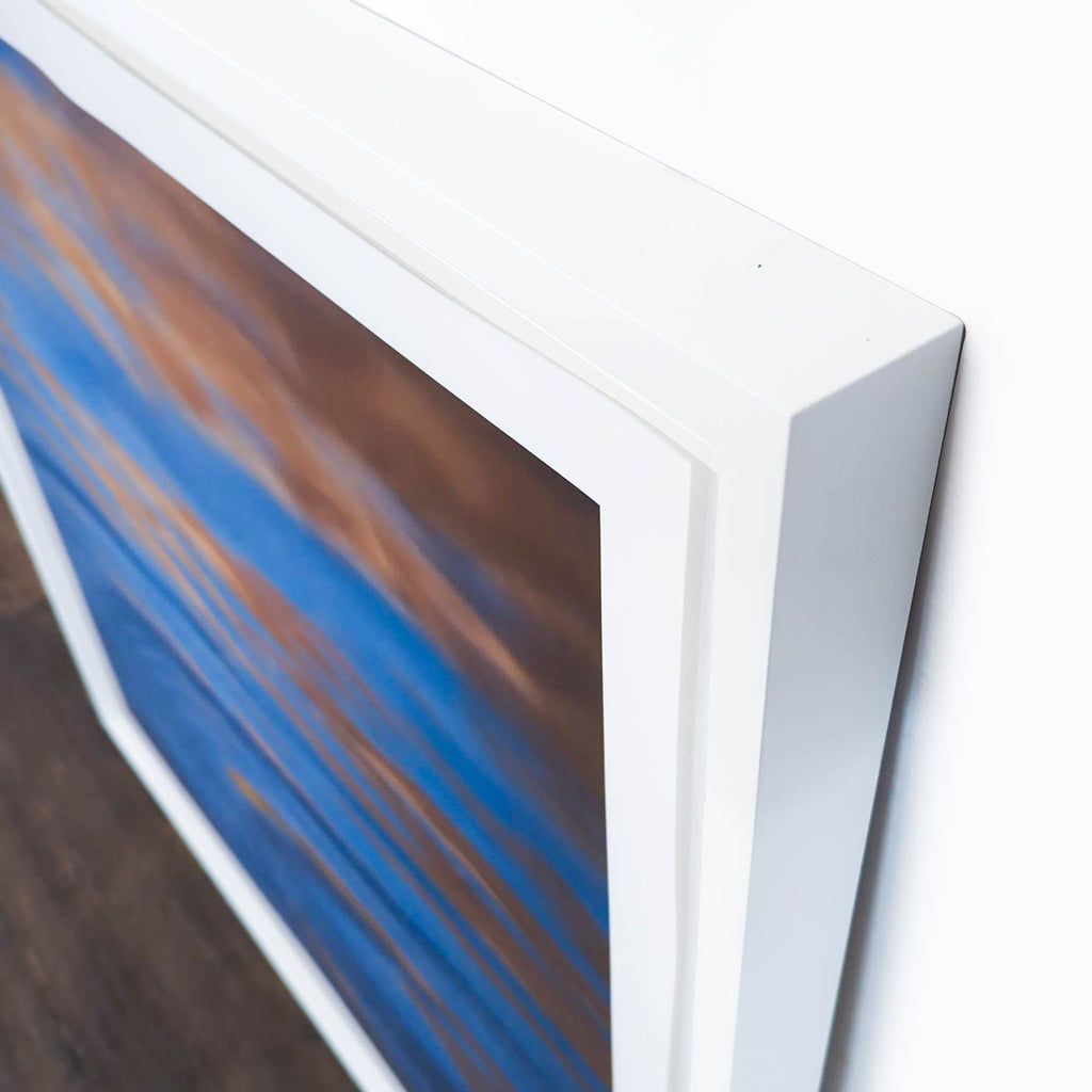 2. Close-up of Reperch brand framed print, showing white frame and abstract blue and gold water artwork.