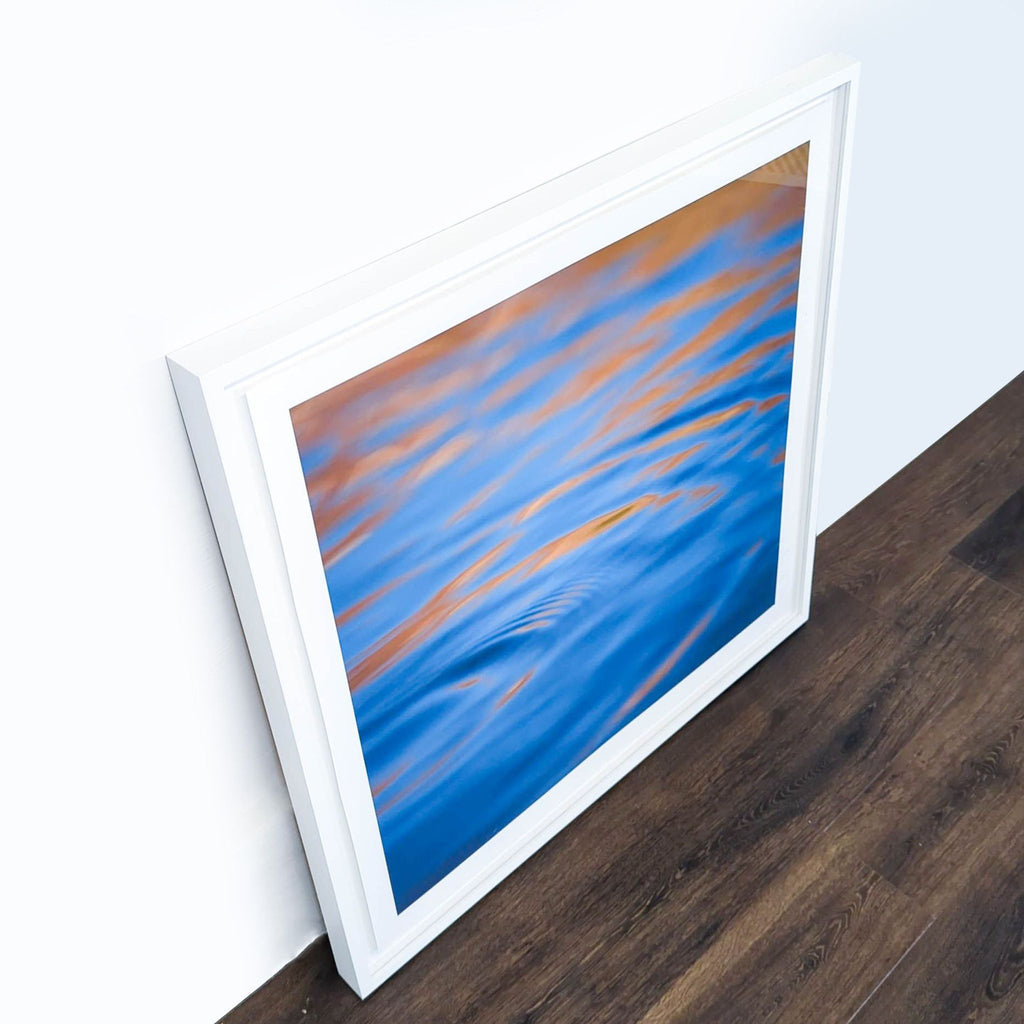 2. Side view of a Reperch print with flowing blue and orange water patterns in a thick white frame.