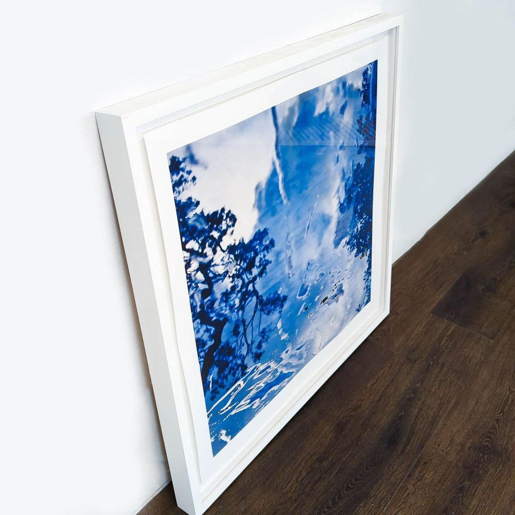 2. Side angle of a Reperch framed print, showing a glossy blue nature scene in a modern white frame.