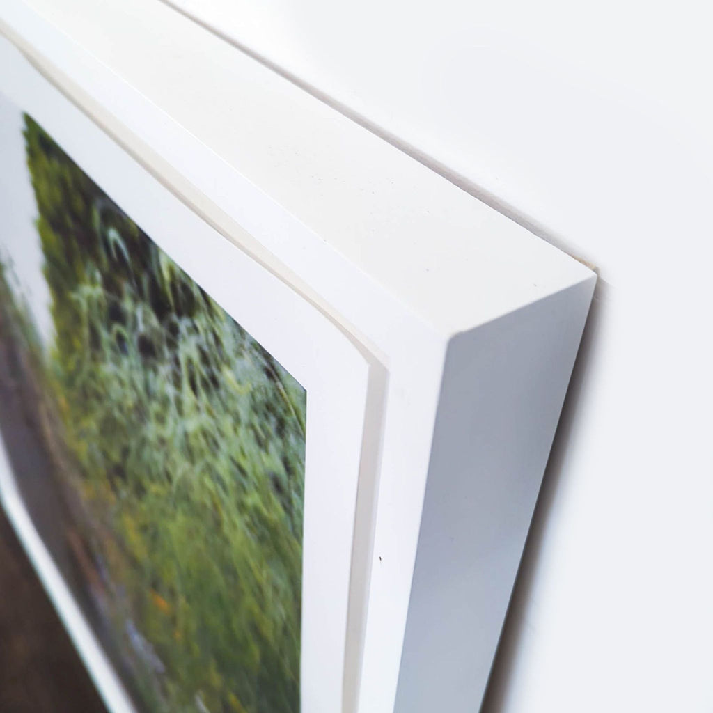 3. Close-up of the white frame on a Reperch garden-themed print, showing its modern and sturdy build.