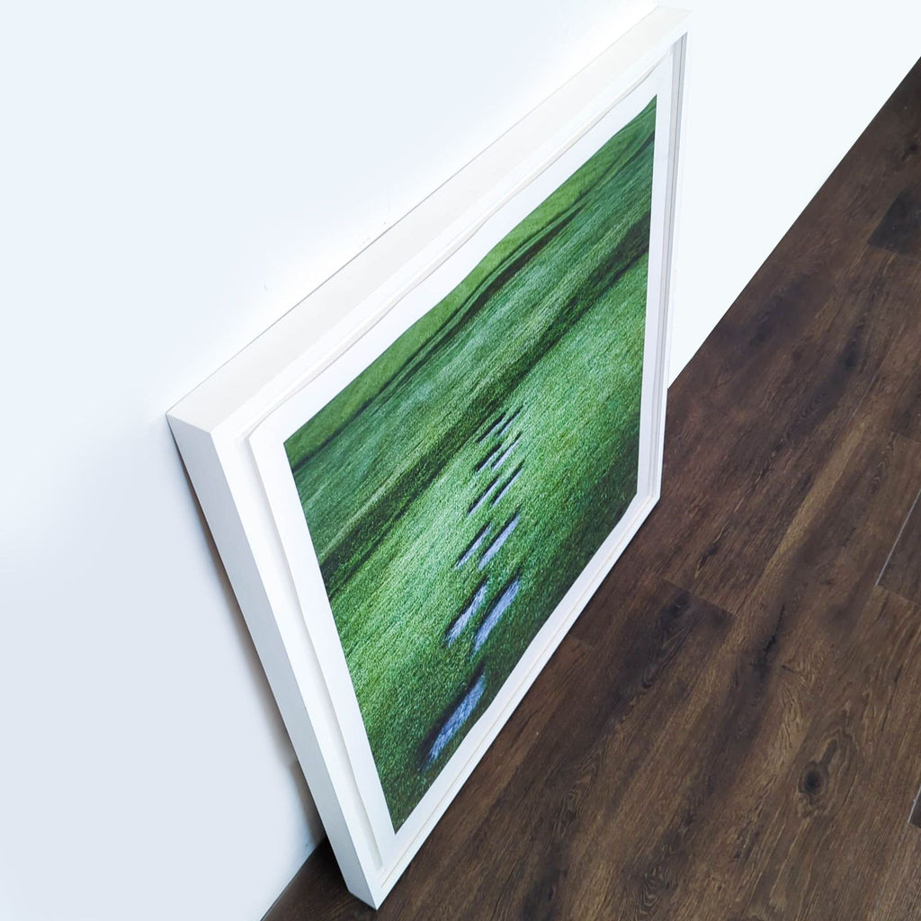 2. Angled view of a Reperch framed print showing a stepping stone path on vibrant grass, leaning on a wall.