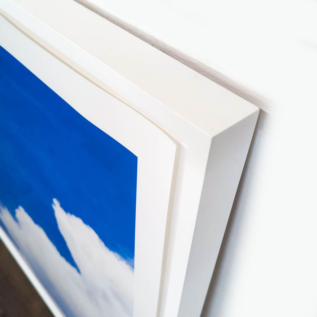 2. Close-up of a white Reperch frame featuring bright cloud artwork, 42"x42", good condition, Prints & Maps.