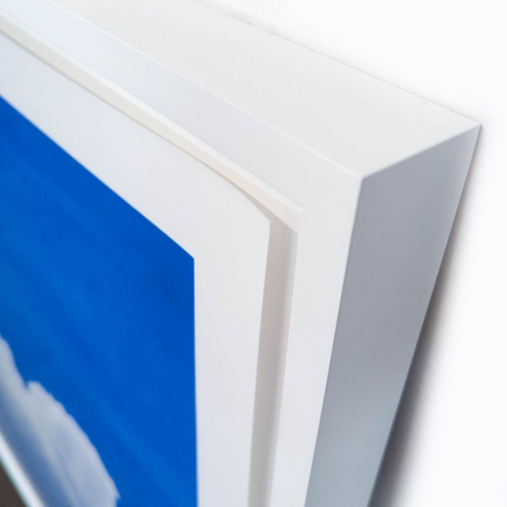 3. Close-up of Reperch print's white frame, highlighting clean corners and quality print of clouds and sky.