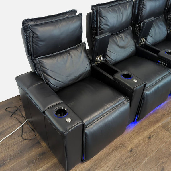 1. Three black Octane reclining theater chairs with cup holders and blue underglow lighting on a wooden floor.