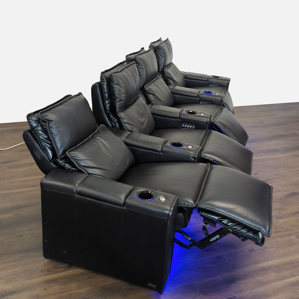 3. Four Octane black leather home theater seats in reclining position, each with cup holder and blue accent lights.