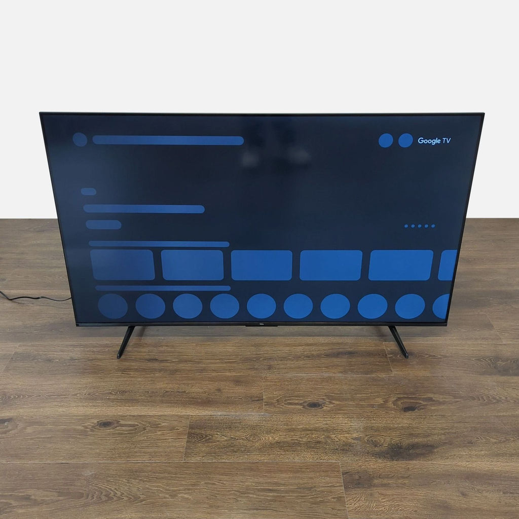 1. Front view of a TCL TV on two legs, displaying the Google TV interface on a large, sleek screen.