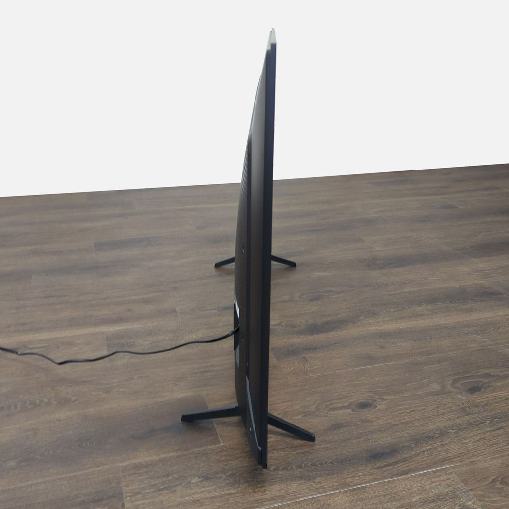 3. Side profile of a slim TCL TV with two stands, highlighting its modern, minimalistic design.