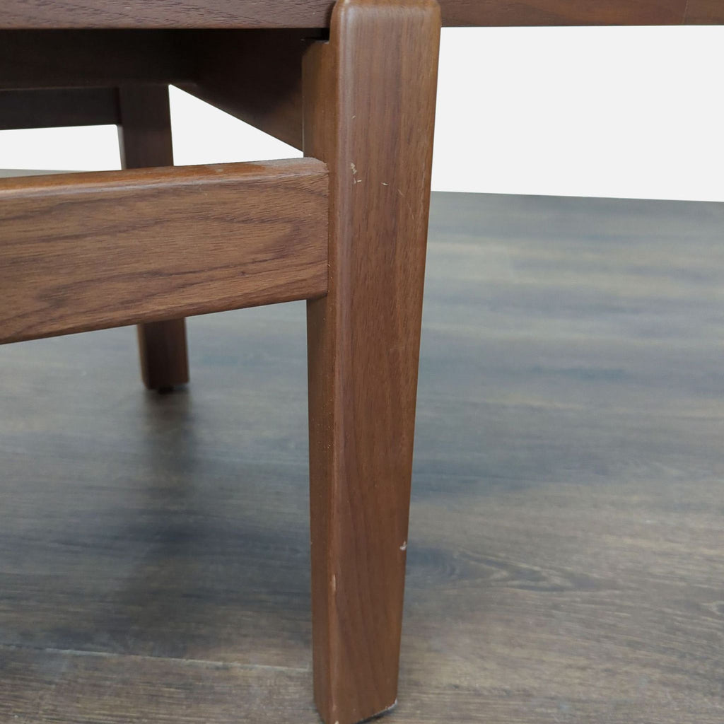 Detail of the Reperch bench’s wooden leg and frame, highlighting clean lines and smooth finish.