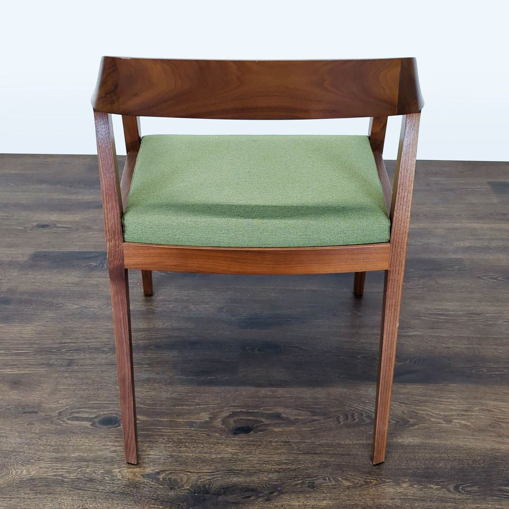 3. Rear view of the Reperch chair, highlighting the curved wooden backrest and green seat upholstery.