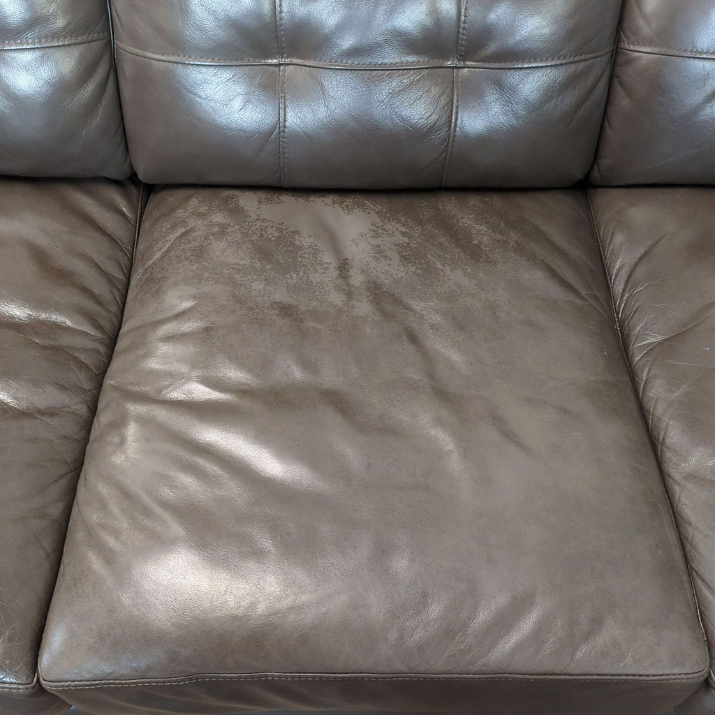 2. Detail of a Reperch 3-seat sofa showing the seat cushion with some visible wear on the leather.