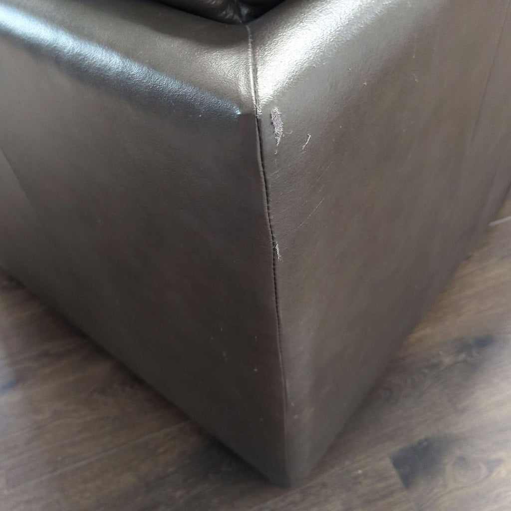 3. Corner view of a Reperch 3-seat sofa in brown leather displaying a small scuff on the armrest.
