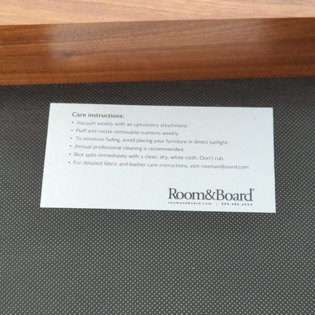 2. Close-up of Room & Board care instructions label attached under the lounge chair with cleaning tips.