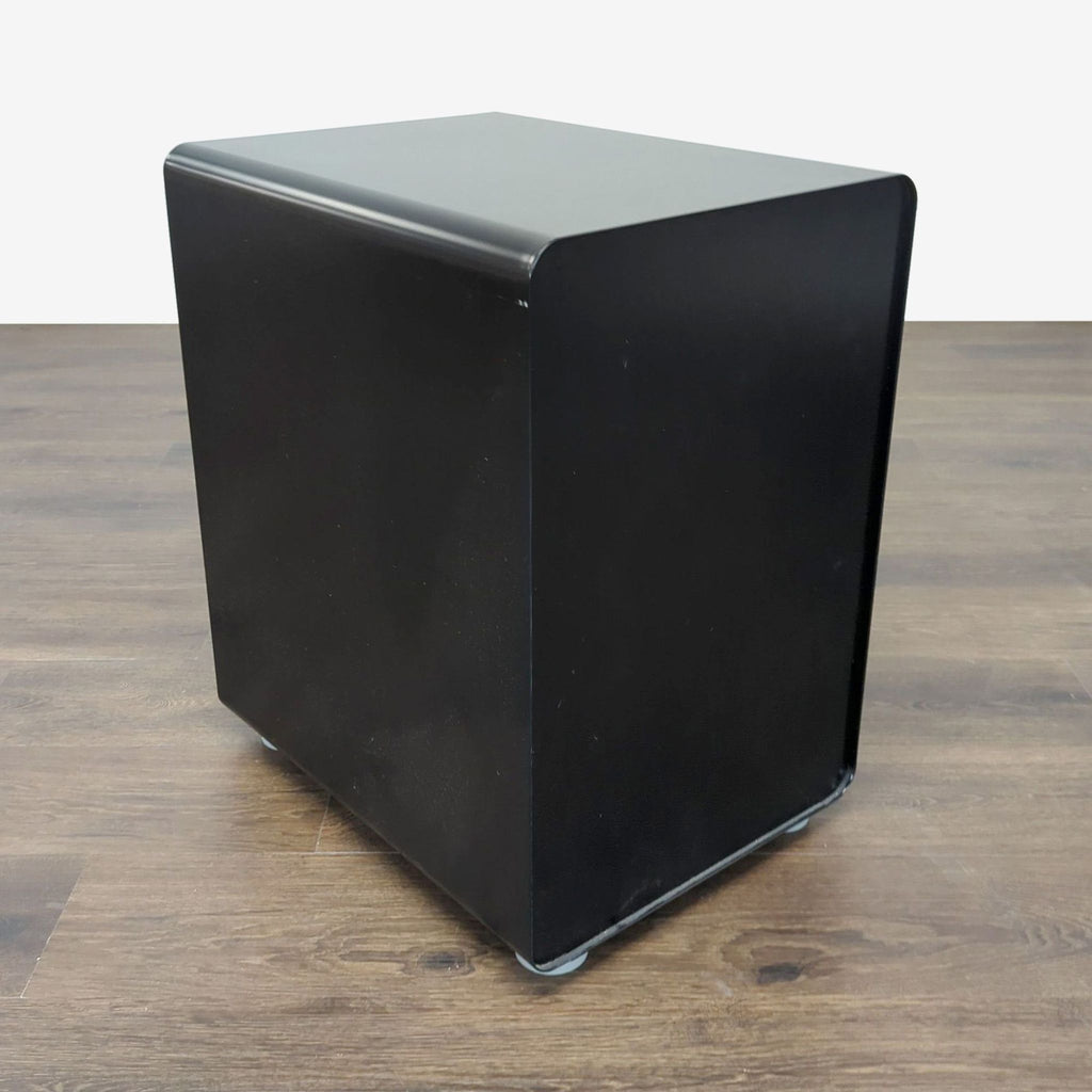 3. Closed Poppin cabinet with a smooth black exterior, placed on a wooden floor.