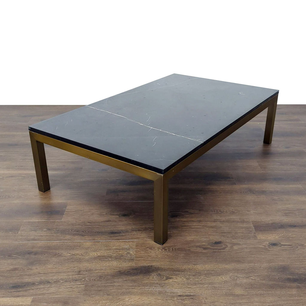 3. Crate and Barrel Parsons Black Marble coffee table with brass frame on wood floor, full view.